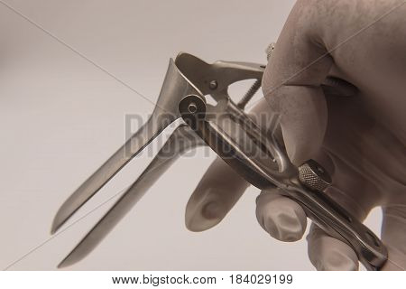 speculum in  hand doctor on white background.Medical concept .