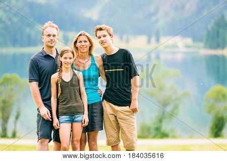 family of four outdoors, by the vilsalpsee in austria