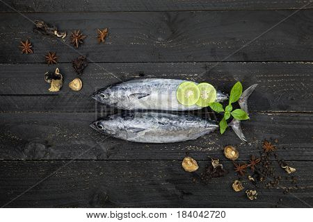 Fresh fish on dark black background Fish with spices and vegetables cooking background concept