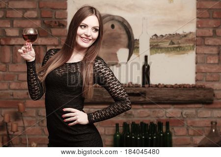 Woman Tasting Wine In Rural Cottage Interior