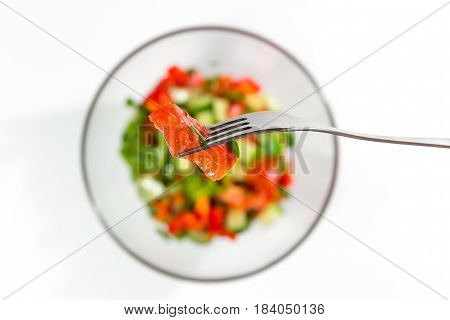 Fresh Red Tomato On A Fork. Fresh Salad With Vegetables Tomatoes, Cucumbers, Lettuce, Salad Leaves O