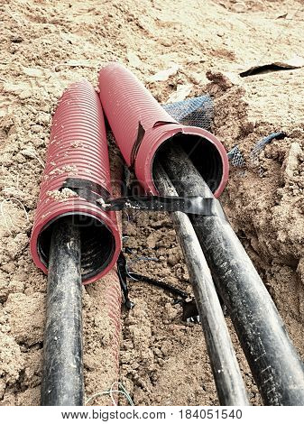 Excavation Of Trench  With Black Cables In Protective Hdpe Tube. Lines Of Metallic And Fiber Optic W