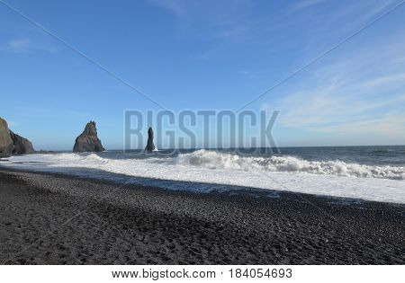 Black sand beach in southern Icleand with sea stacks.