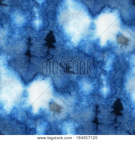 Seamless tie-dye pattern of indigo color on white silk. Hand painting fabrics - nodular batik. Shibori dyeing.