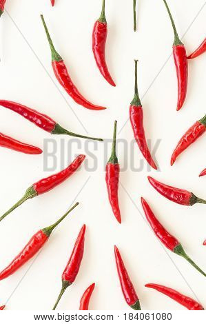 food pattern, popular spices concept - closeup beautiful red hot chili peppers filled white background, green tails, collage of freely lying peppers, top view, flat lay