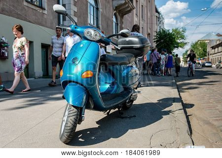 RIGA LATVIA - MAY 24 2014: Miera street Pentecost. Side of the street stands scooter. People walking down the street.