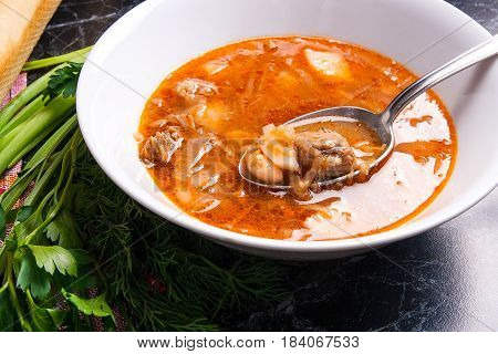 Close Up View Of Plate And Spoon With Red Beetroot Soup Or Borsch On Dark Marble Background. .