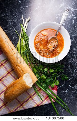 Vegetables And Meat In Red Beetroot Soup Or Borsch In White Plate With Metal Spoon In It On Dark Mar