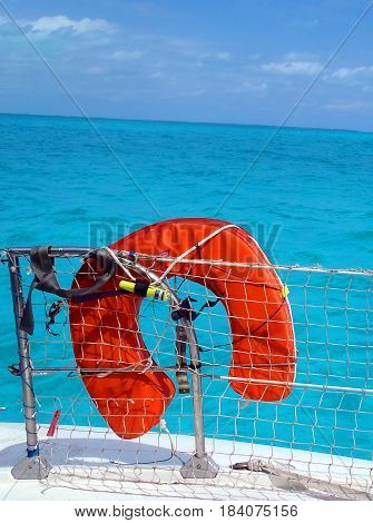 Orange life preserver over a turquoise blue sea