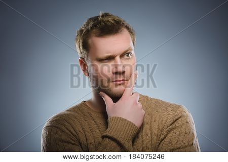 doubt, expression and people concept - man thinking over gray background.