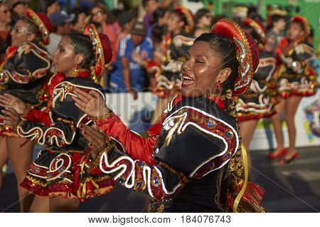 ARICA, CHILE - FEBRUARY 10, 2017: Female members of a Caporales dance group in ornate costumes performing at the annual Carnaval Andino con la Fuerza del Sol in Arica, Chile.