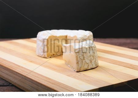 Cheese with white mold. Camembert or brie type on wood table. Healthy breakfast