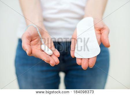 Woman Holding Sanitary Napkin And Tampon In Her Hands.