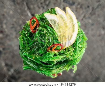 Chuka seaweed salad with reflection over concrete background
