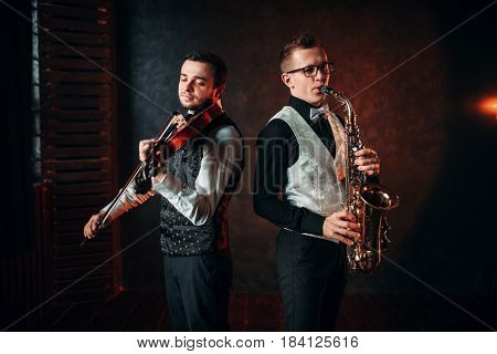Saxophonist and violinst playing classical melody