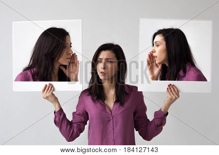 The girl is trying to make the right choice. She holds in her hands two portraits on which she gives herself a clue.