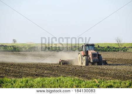 A Tractor With A Plow Lays The Soil. Soil Cultivation On The Fie
