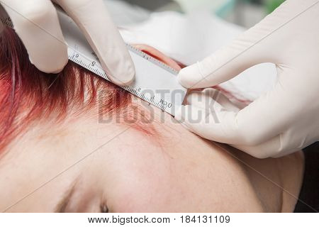 Professional making measurement of the holes place before piercing. Tragus type