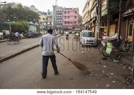 DELHI INDIA-MAR 24 : worker clean dirty street in morning by sweep in chawri bazar near jama masjid in old delhi of delhi on march 24 2015 india