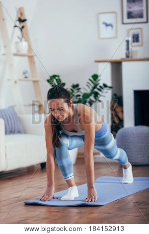 Young cheerful attractive woman practicing yoga, working out wearing sportswear