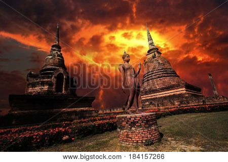 Statue of Buddha between great pagoda with beautiful sky in Wat Sa Si at Sukhothai Historical Park Thailand