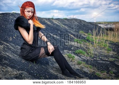 Elf women with fiery hair on nature. Beautiful young fantasy girl. Cosplay character