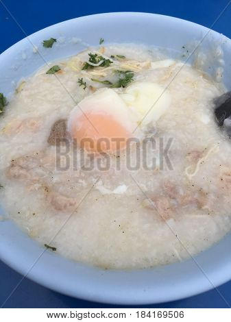 Traditional Thai Porridge Rice Gruel In White Bowl, Congee. In The Street Night Market.