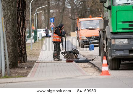 Carnikava, Latvia - April 28, 2017: Workers on a road construction, industry and teamwork.