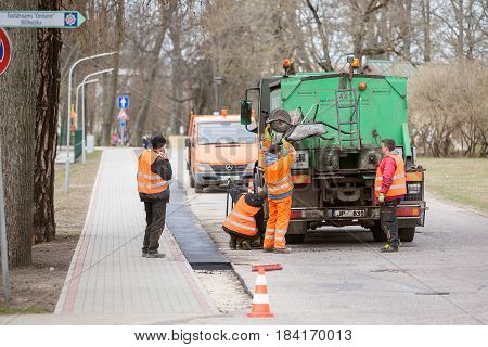 Carnikava, Latvia - April 28, 2017: Workers on a road construction, industry and teamwork.
