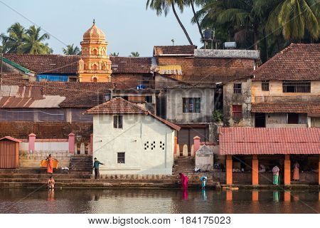 Gokarna, India - January 22, 2016: Unidentified indian people bathing in the sacred lake in Gokarna. The city is a holy pilgrimage site for Hinduists