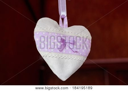 Closeup of heart made of white and violet cloth valentine souvenir