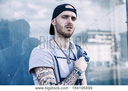 A Rap Singer Is Reflected In A Blue Mirror On The Outskirts