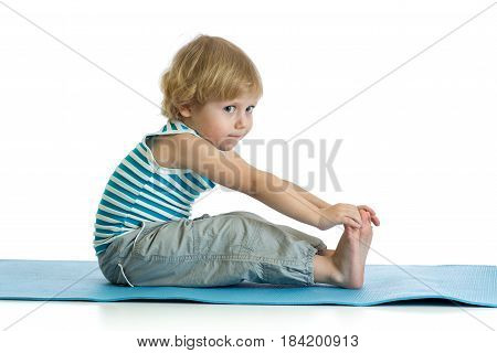 Child boy practicing yoga, stretching in exercise wearing sportswear. Kid isolated over white background