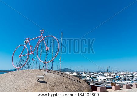 Alghero Italy - April 29 2017: Stylized bike with boats in the background