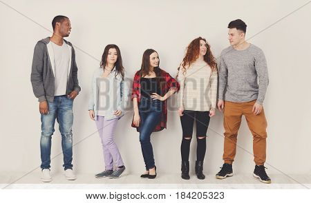 Education concept. Group of diverse students in casual outfits standing in line on white studio background