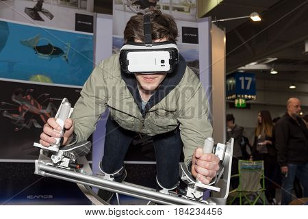 Hannover Germany - March 22 2017: A young man plays with a virtual reality flying skydiving frame of the company Icaros at Cebit 2017. CeBIT is the world's largest trade fair for information technology.