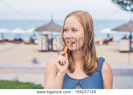 Women Eat Fried Sweet Potatoes In The Park. Junk Food Concept