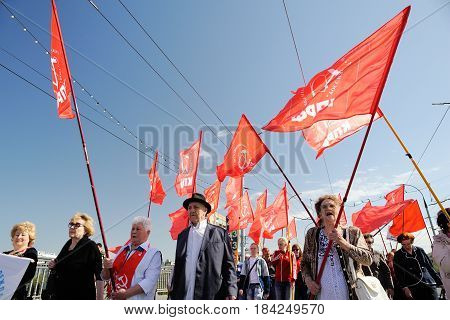 Orel Russia - May 1 2017: May demonstration. People marching with red Communist flags against clear blue sky