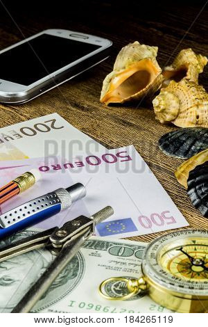 Pensil in travel composition with fotocameramoney and other acsessories on the wooden table