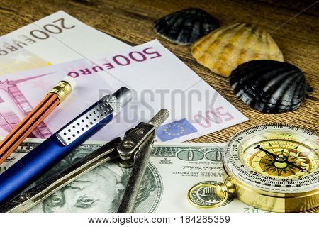 Pensil in travel composition with fotocameramoney and other acsessories on the wooden table