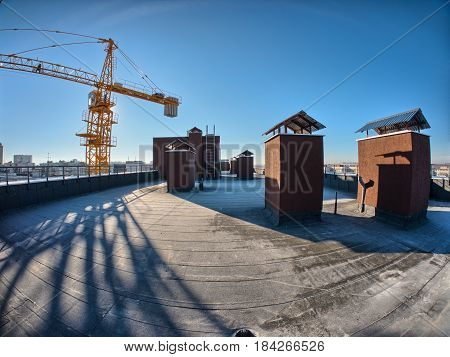 Rooftop view on building underconstruction and yellow crane