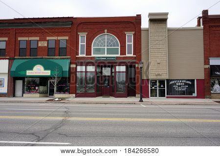 KALKASKA, MICHIGAN / UNITED STATES - NOVEMBER 27, 2016: Businesses in downtown Kalkaska include Edward Jones Investments, Jerry's T.V. and Appliance Service, Forbes Photography, and the Cedar Street Sweets bakery.