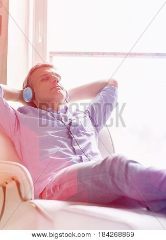Relaxed Middle-aged man listening to music at home
