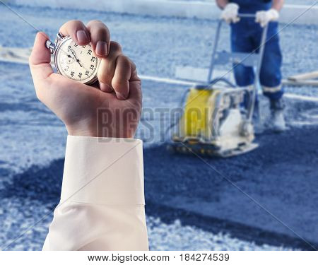 Worker Use Vibratory Plate Compactor And Stopwatch In Male Hand
