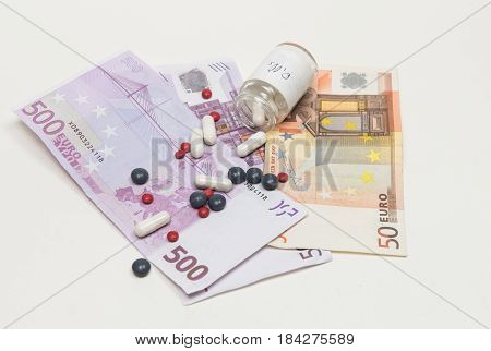 Euro banknotes and metical pills. Concept of expensive health care