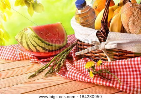 Picnic Wicker Basket With Food On Table In Field Elevated