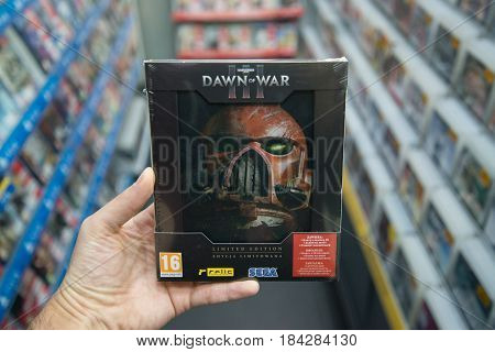 Bratislava, Slovakia, circa april 2017: Man holding Warhamer Dawn of War 3 limited edition videogame on PC in store