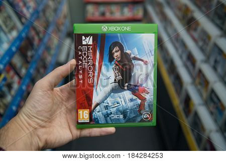 Bratislava, Slovakia, circa april 2017: Man holding Mirror's edge catalyst videogame on Microsoft XBOX One console in store