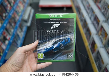Bratislava, Slovakia, circa april 2017: Man holding Forza Motorsport 6 videogame on Microsoft XBOX One console in store