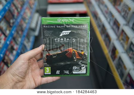 Bratislava, Slovakia, circa april 2017: Man holding Forza Motorsport 5 videogame on Microsoft XBOX One console in store